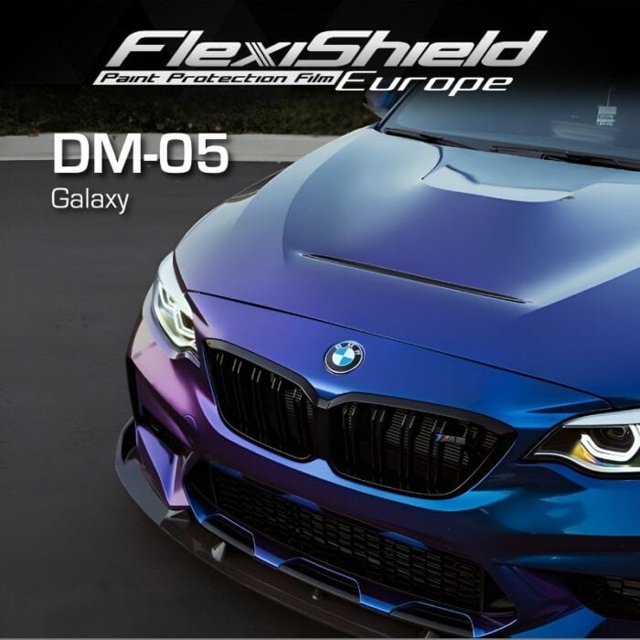 Une voiture BMW aux couleurs bleu et violet irisées est présentée depuis un angle avant, faisant une déclaration cosmique frappante qui met en valeur chaque courbe. L'image comporte le texte « FLEXISHIELD Cosmétique PPF DM-05 Galaxy » dans le coin supérieur gauche. - Tekalab