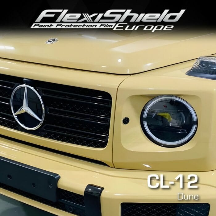 Gros plan d'un SUV Mercedes-Benz beige clair équipé du film de protection de peinture FLEXISHIELD Cosmétique PPF CL-12 Dune pour une protection de peinture haut de gamme. Le marquage FLEXISHIELD met en valeur son film PPF CL-12 Dune, mettant élégamment en valeur la calandre et les phares avant. Le texte FlexiShield Paint Protection Film Europe complète la scène élégante. - Tekalab