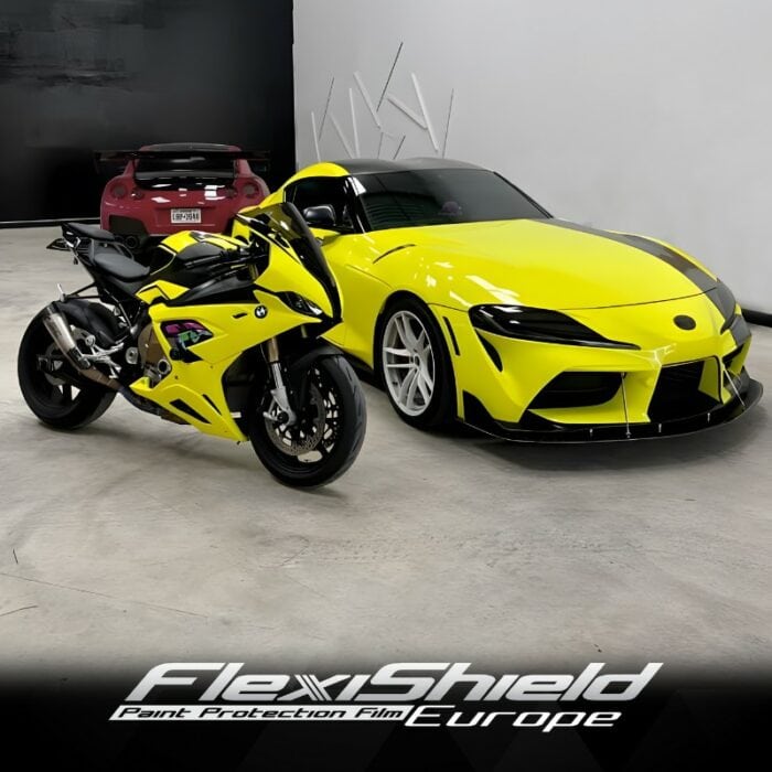 Une moto jaune vif et une voiture de sport assortie, toutes deux dotées de la peinture FLEXISHIELD Cosmétique PPF CL-03 Highlighter Yellow pour une finition impeccable, sont garées dans un showroom moderne au design minimaliste. Le sol gris clair et les murs noirs et blancs du showroom complètent parfaitement les lignes épurées et aérodynamiques des véhicules. - Tekalab