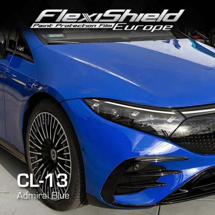 Vue rapprochée de la partie avant d'une voiture bleue présentant un design moderne et des jantes en alliage élégantes. L'image comprend une superposition de texte : FLEXISHIELD Cosmétique PPF CL-13 Admiral Blue, mettant en valeur le film de protection de la peinture qui préserve sa finition sophistiquée. - Tekalab