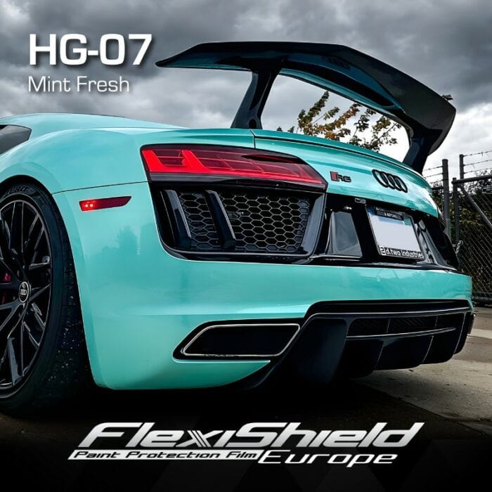 Une Audi R8 vert menthe avec un spoiler brille à lextérieur, protégée par FLEXISHIELD Cosmétique PPF HG-07 MINT FRESH. Son design élégant et sa couleur vibrante contrastent avec le ciel nuageux, avec le texte « HG-07 Mint Fresh » et « FlexiShield Paint Protection » pour souligner son apparence saisissante. - Tekalab