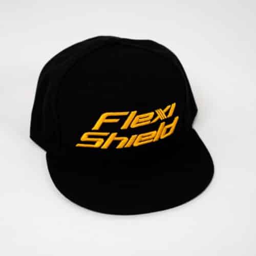 Une casquette de baseball noire avec « Ruban Adhésif Flexishield » brodé en jaune repose sur un fond blanc, avec une visière plate et un devant structuré pour plus de style et de durabilité. - Tekalab