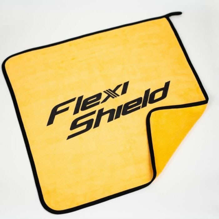 Le chiffon de nettoyage en microfibre Flexishield 40X40 est représenté avec une bordure noire, avec le texte « Flexi Shield » en gras sur son tissu jaune. Un coin est plié, montrant le même dessous jaune vif. - Tekalab