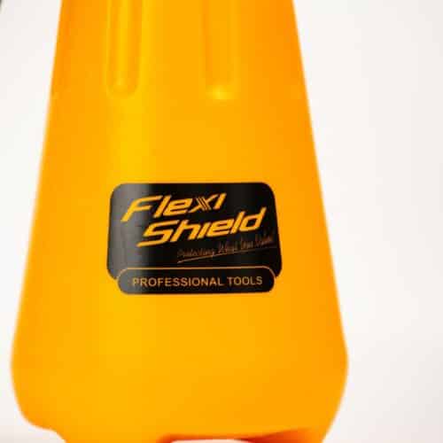 Gros plan dun contenant orange avec une étiquette noire et dorée indiquant « Ruban Adhésif Flexishield ». Le design lisse et effilé présente des renfoncements verticaux, mettant en valeur la marque. Ce contenant polyvalent ressemble à un emballage adhésif haut de gamme dans son esthétique élégante et fonctionnelle. - Tekalab