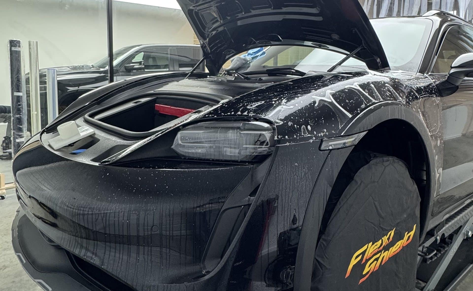 Porsche Taycan en atelier, face avant protégée par un film PPF Flexishield