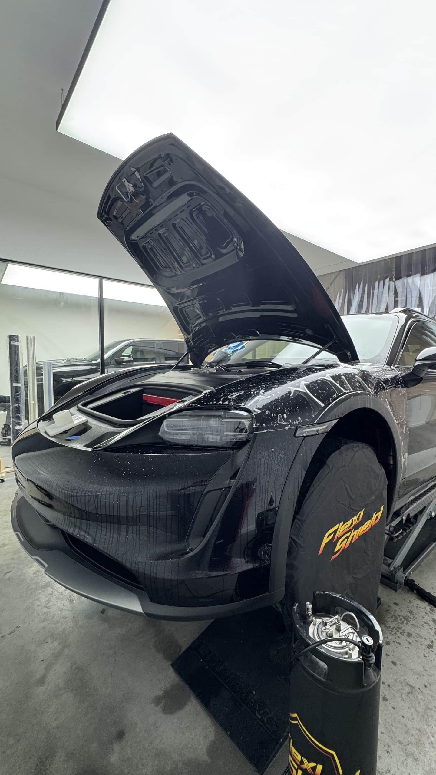 Porsche Taycan en atelier, face avant protégée par un film PPF prédécoupé Flexishield